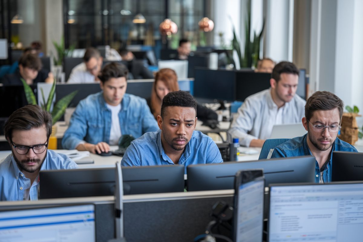 Des ingénieurs de Tailwind CSS discutant dans un bureau moderne