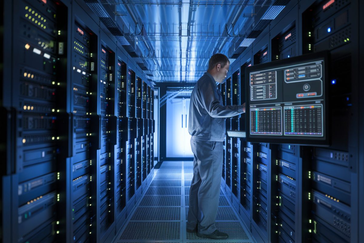 Un technicien dans une salle de serveurs high-tech surveillant des données
